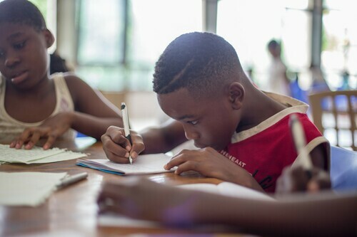 A student writes at a desk.